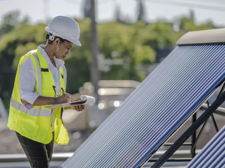 Worker inspecting solar hot water unit