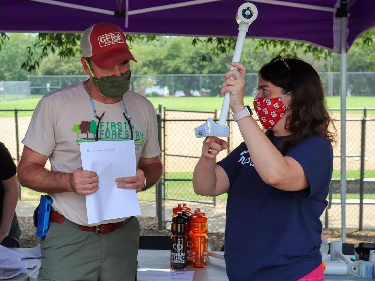 An adult holds up a thermal sensor at an urban heat mapping event in North Carolina.
