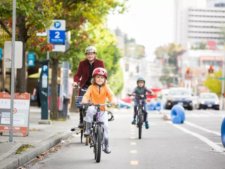 A young child riding their bicycle in a dedicated bike lane on Broadway in Seattle, Washington