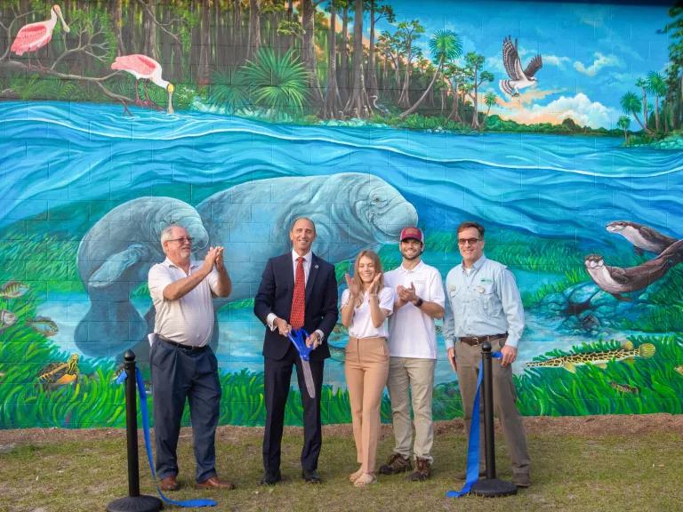 Group of people standing in front of mural