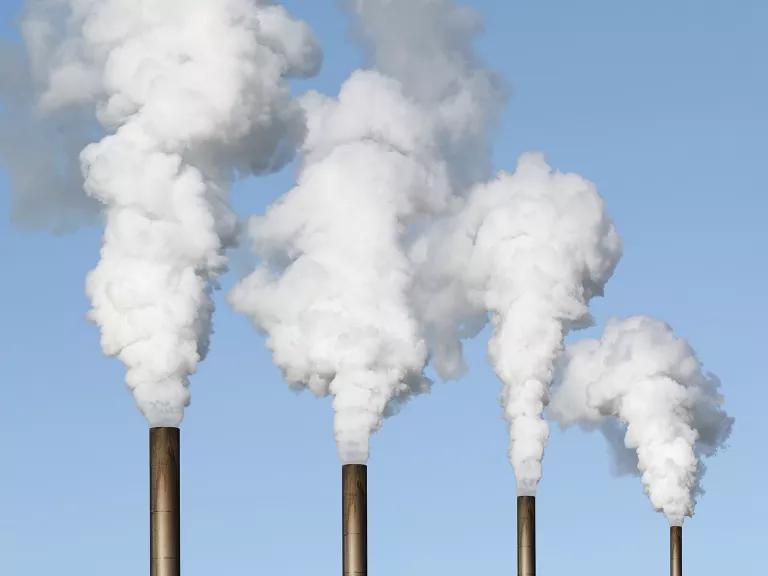 Emissions billowing from smokestacks. | iStock