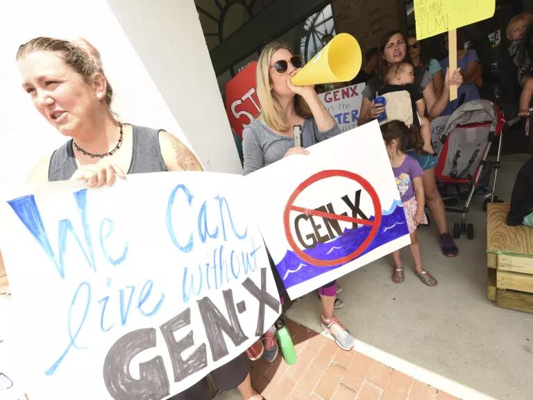People holding up signs that say things like "We can live without Gen-X"