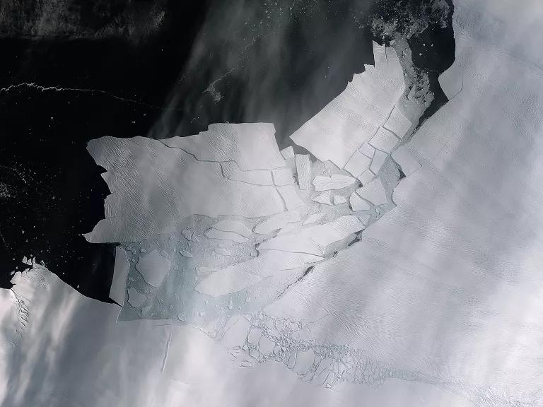 An aerial view of an iceberg with many cracks in it