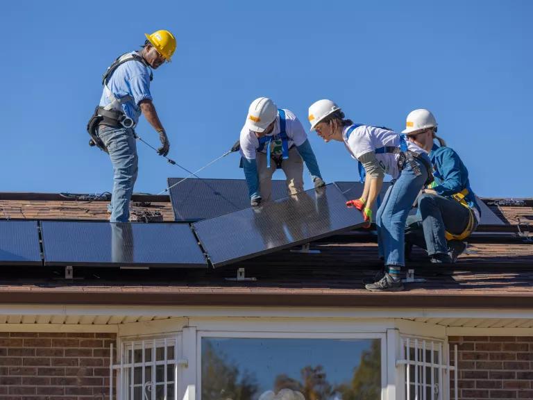 Staff from the National Renewable Energy Laboratory (NREL) and GRID Alternatives Colorado staff installing rooftop solar panels during a GRID Alternatives event at a home in Colorado on October 20, 2023. 

The 6.7kW solar project should provide the home with $1,200 annual savings over the next 20 years.