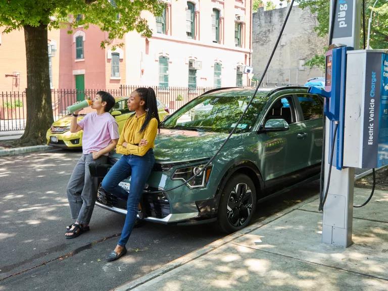 Women waiting for their electric car to charge at a public charging station in Brooklyn, New York City.