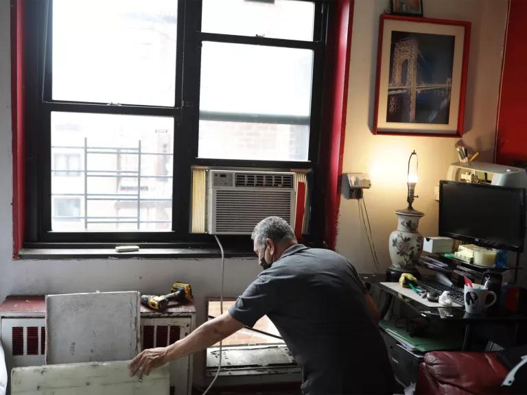 A person in a home working on an air conditioner