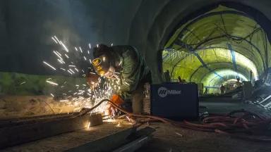 A worker welding in a train tunnel under construction in New York City 
