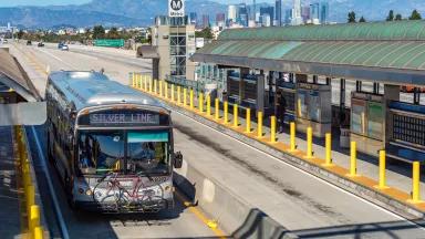A Metro Silver Line bus driving through a dedicated bus lane on the Harbor Transitway in the bus rapid transit system of Los Angeles, California