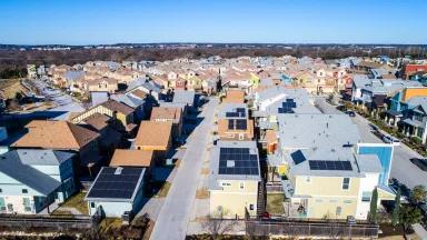 An aerial view of homes with rooftop solar panels in the suburbs of Austin, Texas.