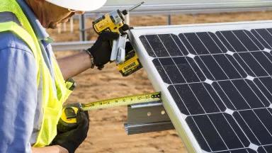 A worker installing solar panels at the 2 megawatt CoServ Solar Station in Krugerville, Texas.