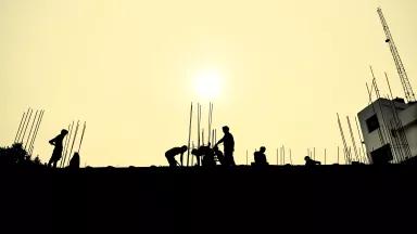 Workers install equipment under a hazy sun