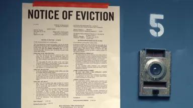 A door with the number "5" on it with a sign that says "Notice of Eviction"