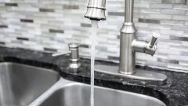 Water flows from a kitchen faucet