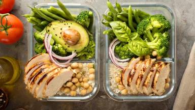 Rectangular glass food storage containers hold sliced chicken, chick peas, rice, broccolli, avocado, and green beans