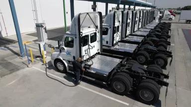 An OK Produce driver charging an electric semi-trailer truck at a North American Council for Freight Efficiency (NACFE) Run on Less — Electric DEPOT in Fresno, California, on June 14, 2023.