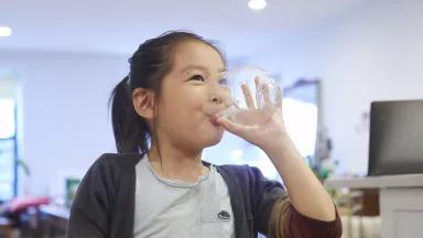Sota Gunji, 6, drinking a glass of water in the kitchen at his home in Brooklyn, New York City.