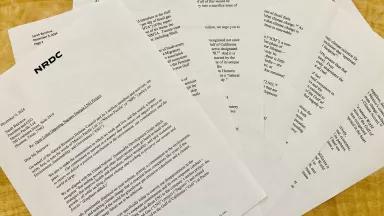 Pieces of paper with typed writing on them, spread out like a fan on a yellow background