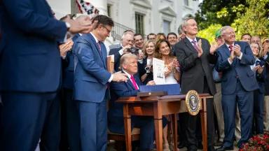 President Donald Trump holds up a signed copy of the One Big Beautiful Bill Act on the South Lawn of the White House in Washington, DC, on July 4, 2025.