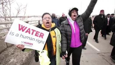 People participate in a national mile-long march to highlight the push for clean water in Flint, Michigan, on February 19, 2016.