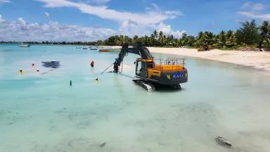 Workers secure a geotextile mega container in place while an excavator pumps sediment to fill it as part of the Tuvalu Coastal Adaptation Project (TCAP) on Funafuti, Tuvalu, in November 2022.

TCAP is funded by the Green Climate Fund (GCF), with additional contributions from Australia's Department of Foreign Affairs and Trade (DFAT) and co-financing from the Government of Tuvalu. 

The reclamation incorporates drainage to protect from heavy rainfall and a small harbor facility to provide continued community