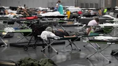 People resting on cots inside a cooling center set up at the Oregon Convention Center in Portland, Oregon, on June 27, 2021.