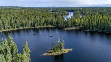 Guests from NRDC's boreal forest excursion paddling canoes on Little Caribou Lake near Armstrong, Ontario, Canada, on September 11, 2025.