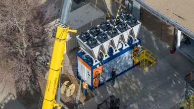 Workers lower a heat exchanger into place during an installation of AtmosZero's Boiler 2.0 to produce industrial steam and support this customer's sustainability initiatives.