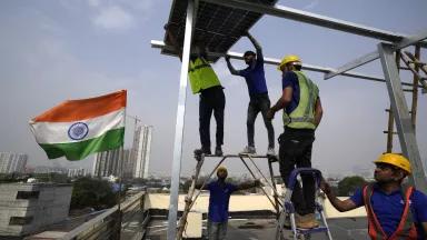 Workers of Solar Square place a panel on the rooftop of a residence in Gurugram on the outskirts of New Delhi, India, on February 20, 2024.