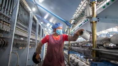 A worker on the production line at a textile and plastic manufacturing facility. The nylon elastic yarn used in the production of clothing is transformed into the nylon elastic yarn used in the elastic belt of mask. Haian City, Jiangsu Province, China, on April 19, 2020.