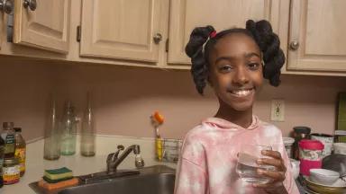 Rhys, 11, drinking a glass of water in the kitchen of her New York City apartment.