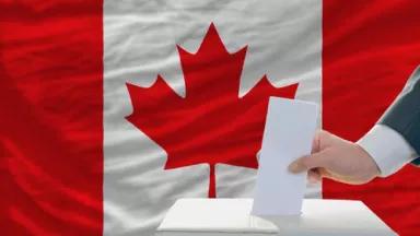 man-putting-ballot-in-a-box-during-elections-in-canada.jpg