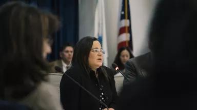 A photo of Nancy Beck sitting among a group of people