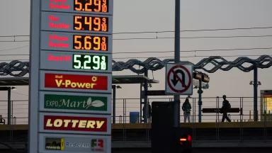 A gas station sign shows prices above $5 per gallon