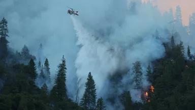 A helicopter flying over a forest fire