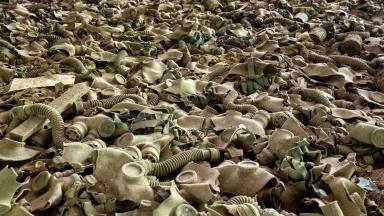 A vast pile of dusty beige gas masks