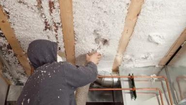 Worker installing insulation in a building