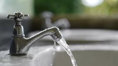 Water flows from a sink faucet
