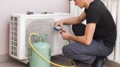 Heat pump installer showing refrigerant tank