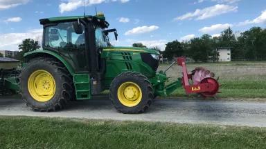 Tractor with roller crimper attached to front