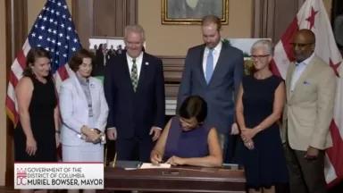 Picture of Mayor Bowser signing DC Green Bank Bill