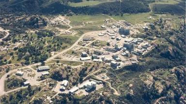 An aerial view of cluster of buildings surrounded by low rocky hills
