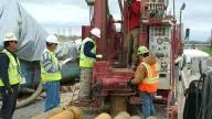 Workers surrounding and drilling a well in Paducah, Kentucky for groundwater cleanup. 