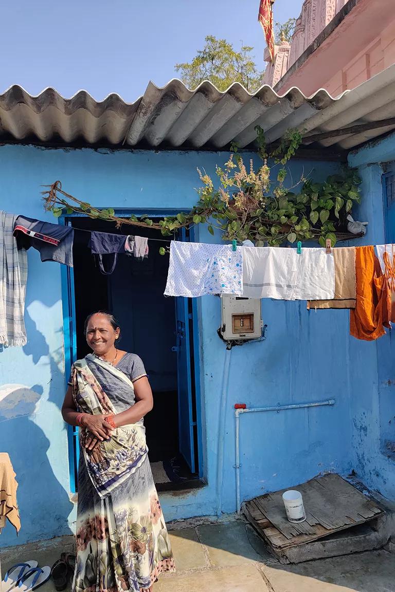 Two photos side-by-side. On the left, a woman stands in front of her home with laundry hanging to dry. On the right, a roof is in the process of being painted white for cooling.